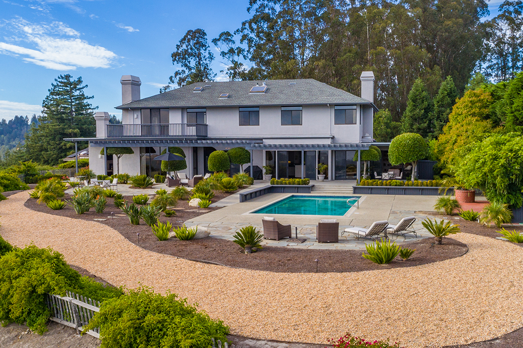 Home with an open backyard, pool and gravel pathway